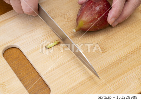 秋の味覚採れたて無花果を包丁でカットする 131228989