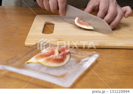 秋の味覚採れたて無花果を包丁でカットする 131228994