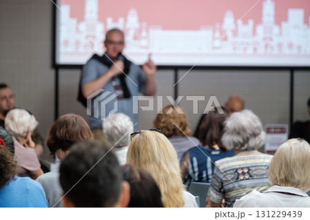 Conference presentation: speaker addresses audience against city skyline backdrop Conference presentation: speaker addresses audience against city skyline backdrop 131229439