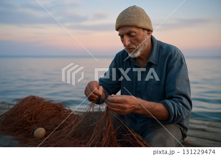 AI generated image of an elderly fisherman mending his nets on a tranquil dock at dawn with soft pastel sky and sea in the background. Evoking peace, dedication, and craftsmanship. 131229474
