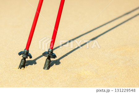 Nordic walking. Red sticks on the sandy beach 131229548
