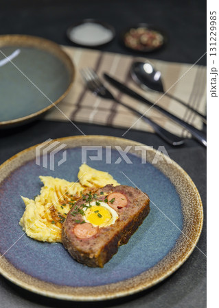 Typical Czech cuisine minced roast pork and beef with egg, sausage and mashed potatoes 131229985