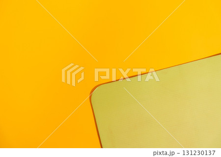 Minimal yellow background with corner of green fitness mat textured copy space workout backdrop Minimal yellow background with corner of green fitness mat textured copy space workout backdrop 131230137