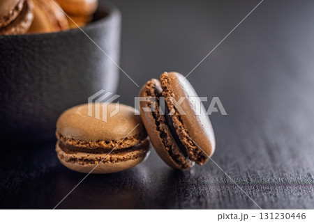 Different flavors of macarons. Colourful macaroons on black table. Different flavors of macarons. Colourful macaroons on black table. 131230446