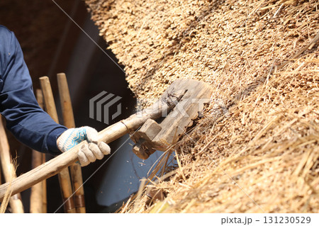 茅葺き屋根の茅を押し整える職人 131230529