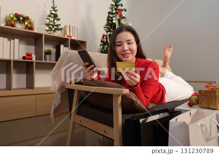 Woman shopping online for Christmas gifts with credit card Woman shopping online for Christmas gifts with credit card 131230789