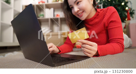 Festive Online Shopping. Woman with credit card using laptop for Christmas gifts. Festive Online Shopping. Woman with credit card using laptop for Christmas gifts. 131230800