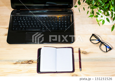 laptop glasses and notepad lie on a wooden table, online learning, work from home laptop glasses and notepad lie on a wooden table, online learning, work from home 131231526