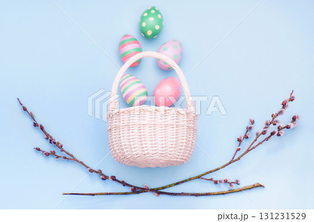 basket with Easter eggs and branches of flowering willow on a blue background basket with Easter eggs and branches of flowering willow on a blue background 131231529