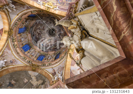 Statue overlooking the frescoes and dome of St. Nicholas Church in Prague 131231643