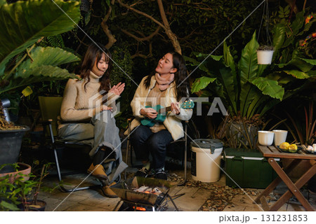 Winter camp outdoor friend people forest woman happy, playing ukulele and enjoying warm campfire, sharing laughter during relaxing cozy winter evening leisure getaway. Winter camp outdoor friend people forest woman happy, playing ukulele and enjoying warm campfire, sharing laughter during relaxing cozy winter evening leisure getaway. 131231853