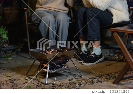Winter camp outdoor two women friends forest happy, enjoying warmth from glowing fire during peaceful evening gathering, activity perfect for chilly winter weather. Winter camp outdoor two women friends forest happy, enjoying warmth from glowing fire during peaceful evening gathering, activity perfect for chilly winter weather. 131231895