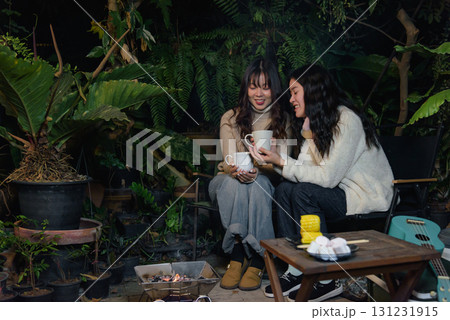 Happy woman friend people enjoy winter outdoor camp activities, forest night, warm drink barbecue create cozy winter evening atmosphere. Happy woman friend people enjoy winter outdoor camp activities, forest night, warm drink barbecue create cozy winter evening atmosphere. 131231915