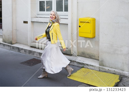 Attractive gray-haired woman in her sixties in a yellow jacket Attractive gray-haired woman in her sixties in a yellow jacket 131233423