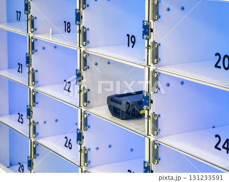 Modern storage lockers with a portable device inside at a busy urban location Modern storage lockers with a portable device inside at a busy urban location 131233591
