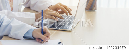 Banner hands of two women doctor medical lab discussing together healthcare teamwork. Panorama Two asian women doctors meeting write prescription medical clinic office using laptop with copy space. Banner hands of two women doctor medical lab discussing together healthcare teamwork. Panorama Two asian women doctors meeting write prescription medical clinic office using laptop with copy space. 131233679