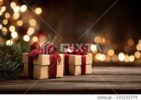 Christmas gifts with red ribbons and pine branches on wooden table 131233774