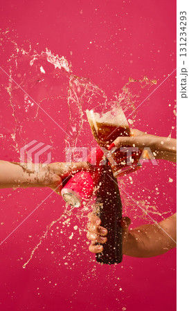 Beer splash explosion with can, glass and bottle on pink background Beer splash explosion with can, glass and bottle on pink background 131234293