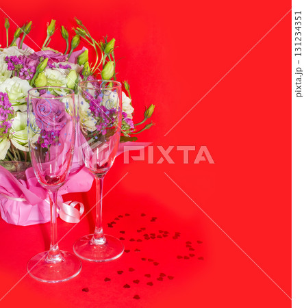 Valentine day romantic flat lay image. Wine glasses, heart shaped candles and red roses with red ribbon on white wooden background. 131234351