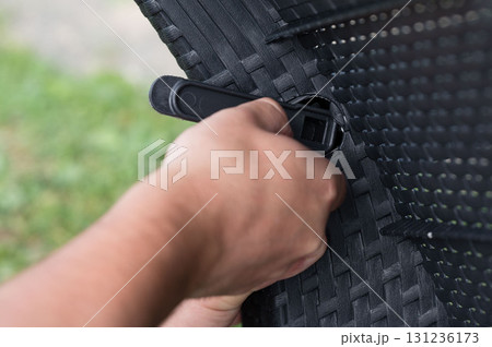 Assembling outdoor furniture with a simple tool. Easy setup for relaxing comfort. Assembling outdoor furniture with a simple tool. Easy setup for relaxing comfort. 131236173