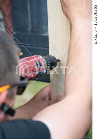 Screwing the board with a screwdriver, installing a wooden gazebo. Screwing the board with a screwdriver, installing a wooden gazebo. 131236265