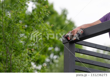 The craftsman screws into the wooden beam to connect the wall to the upper beam. The craftsman screws into the wooden beam to connect the wall to the upper beam. 131236273