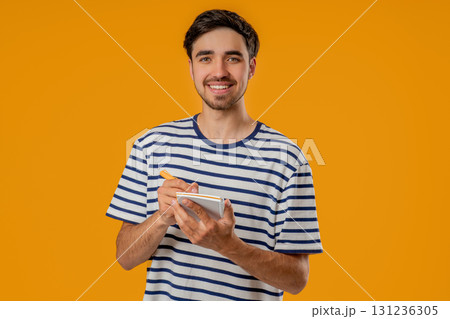 Handsome Young Man Writing Notes Planner, Pen.student Writes Plans, To-Do List Handsome Young Man Writing Notes Planner, Pen.student Writes Plans, To-Do List 131236305