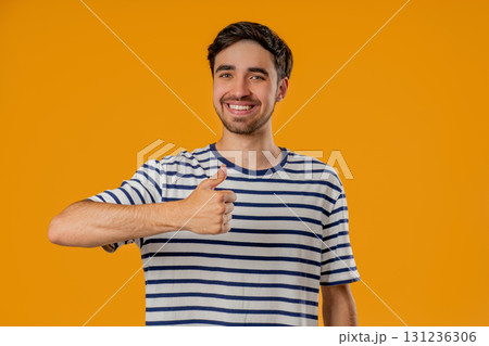 Handsome man With Hand Sign Like,thumbs Up Gesture. Happy Young Guy On yellow 131236306