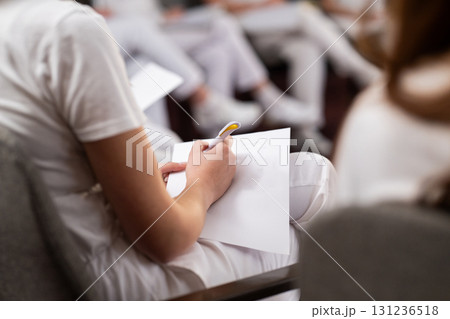Close up of a student holding a pen and writing notes in a notebook during a professional training and education session in a wellness and therapy course Close up of a student holding a pen and writing notes in a notebook during a professional training and education session in a wellness and therapy course 131236518