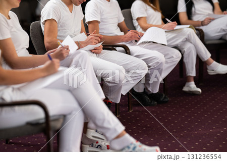 Close up of a student holding a pen and writing notes in a notebook during a professional training and education session in a wellness and therapy course Close up of a student holding a pen and writing notes in a notebook during a professional training and education session in a wellness and therapy course 131236554