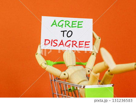 Agree to disagree symbol. Concept words Agree to disagree on beautiful white card. Beautiful orange background. Businessman model in shop cart. Business and agree to disagree concept. Copy space. Agree to disagree symbol. Concept words Agree to disagree on beautiful white card. Beautiful orange background. Businessman model in shop cart. Business and agree to disagree concept. Copy space. 131236583