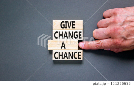 Give change a chance symbol. Concept words phrase Give change a chance on beautiful wooden blocks. Beautiful grey paper background. Businessman's hand. Business Give change a chance concept Copy space 131236653