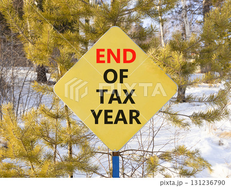 End of tax year symbol. Concept words phrase End of tax year on beautiful yellow road sign. Beautiful winter forest background. Business End of tax year concept. Copy space. End of tax year symbol. Concept words phrase End of tax year on beautiful yellow road sign. Beautiful winter forest background. Business End of tax year concept. Copy space. 131236790