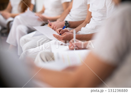 Close up of a student holding a pen and writing notes in a notebook during a professional training and education session in a wellness and therapy course Close up of a student holding a pen and writing notes in a notebook during a professional training and education session in a wellness and therapy course 131236880