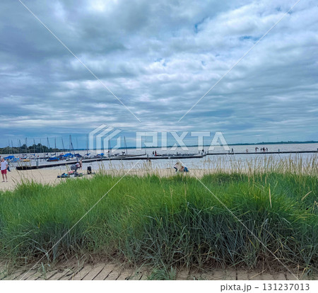 Sandy beach with grass and a view of the lake. A place for walking or relaxing with the whole family 131237013