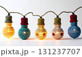 String of Decorative Crochet Light Bulbs with Warm Yellow Glow on White Background 131237707