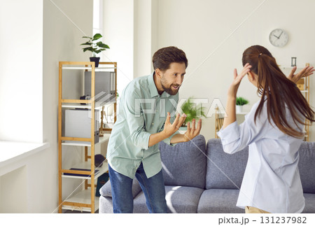 Angry young couple arguing at home, facing relationship problems, husband shouting at stressed wife. 131237982