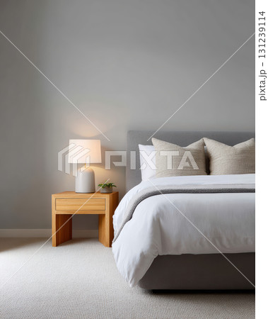 Serene modern bedroom interior with comfortable bed. minimalist home design for peaceful relaxation. Simple decor includes lamp and wooden furniture 131239114