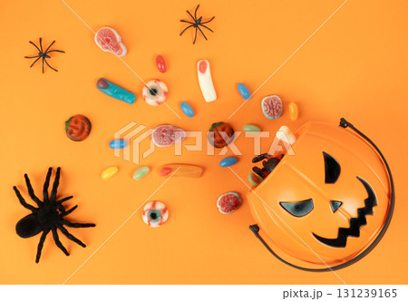 Halloween pumpkin basket with candies and spiders 131239165