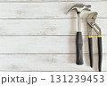 白い木目背景で右端にプライヤーと金槌 131239453