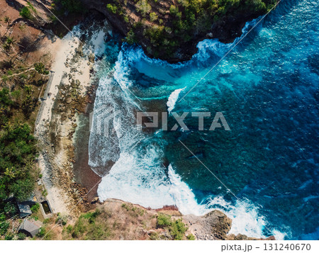 Rocky beach coastline with ocean waves crashing against cliffs. 131240670