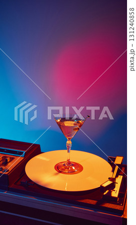 Martini cocktail on vinyl turntable with vibrant neon background 131240858