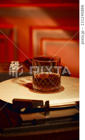 Glass of whiskey placed on vinyl record under warm red light Glass of whiskey placed on vinyl record under warm red light 131240866