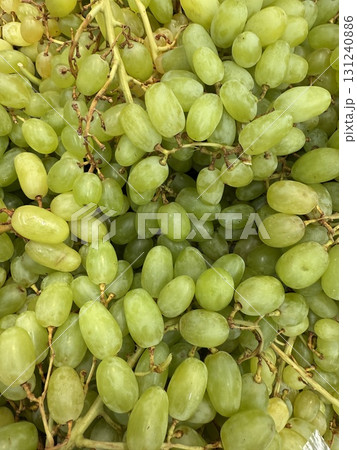 White grapes, sweet, seedless, with translucent, tender, and juicy flesh. A container filled with grapes. 131240886