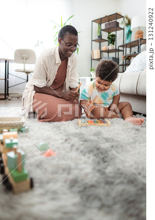 Mother and child playing xylophone enjoying musical activity 131240922