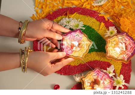 Placing Diwali Candles with Care on Rangoli Placing Diwali Candles with Care on Rangoli 131241288