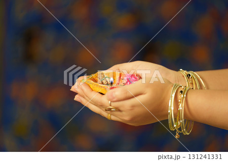 Hands holding decorative Diwali items with vibrant colors Hands holding decorative Diwali items with vibrant colors 131241331