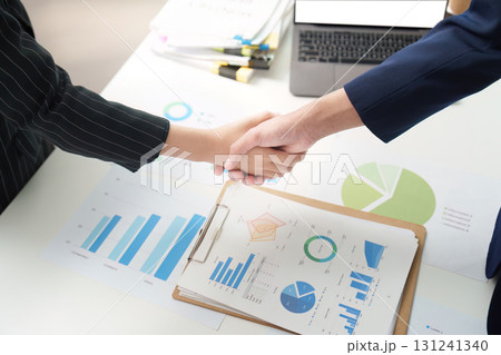 Business Partnership. Professionals shaking hands over financial reports. Business Partnership. Professionals shaking hands over financial reports. 131241340
