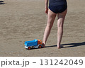 Woman pulling toy truck on sandy beach during summer vacation 131242049