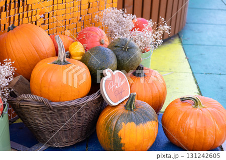 Vibrant pumpkins in rustic basket and on ground with a Hello Pumpkin sign, celebrating autumnal harvest, Halloween, and Thanksgiving decor 131242605